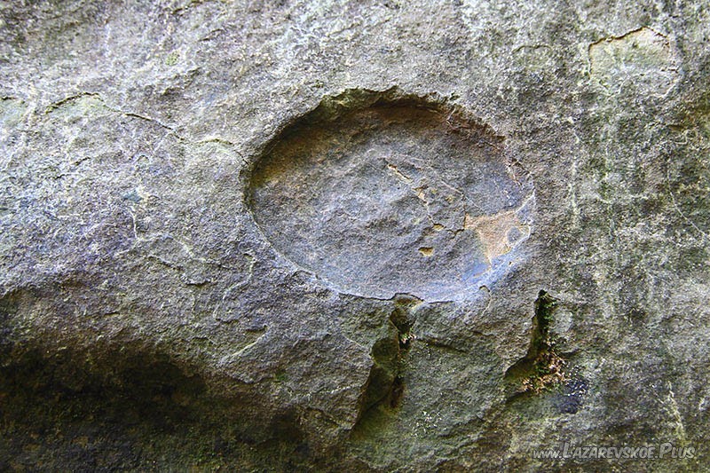 Круглый отпечаток с ровным дном. Возможно внутри какой-то рисунок.